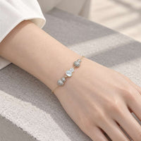 Gourd-Hulu cubic zirconia bracelet with a delicate gold-tone chain, sparkling clustered charms, and a white gourd-shaped centerpiece.