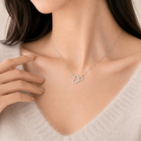 Heart cubic zirconia necklace with two interlocking heart pendants and rhodium plated finish