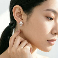 Freshwater pearl stud earrings with cubic zirconia V-shaped rim and rhodium plating