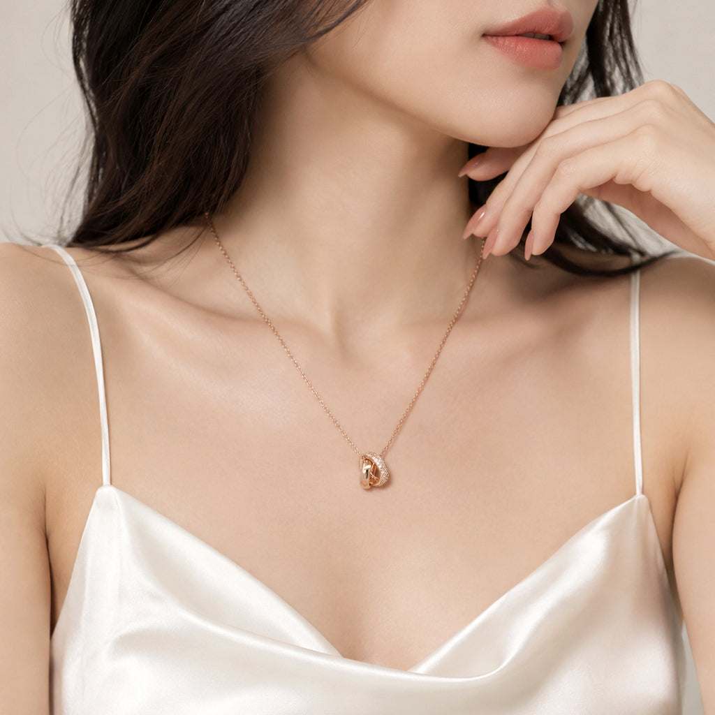 Rose gold interlocking ring necklace with cubic zirconia pendant on adjustable chain