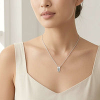Close-up of rhodium-plated tunnel cubic zirconia necklace with oval-shaped pendant on adjustable chain