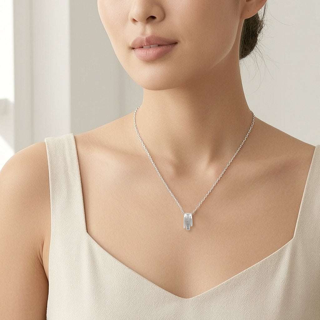 Close-up of rhodium-plated tunnel cubic zirconia necklace with oval-shaped pendant on adjustable chain