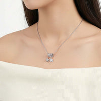 A close-up of a model wearing a rhodium plated chain necklace with a pendant featuring two shiny stars.