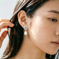 Close-up of rhodium-plated freshwater pearl hoop earrings with cubic zirconia and latch back closure