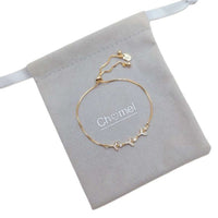 Cubic Zirconia Tennis Bracelet in gold-plated metal with delicate chain and sparkling floral accents, adjustable slider clasp