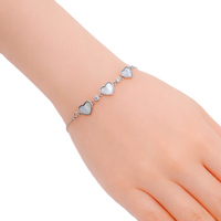 Cubic Zirconia Tennis Bracelet with three silver-toned mother-of-pearl heart charms and sparkling stones