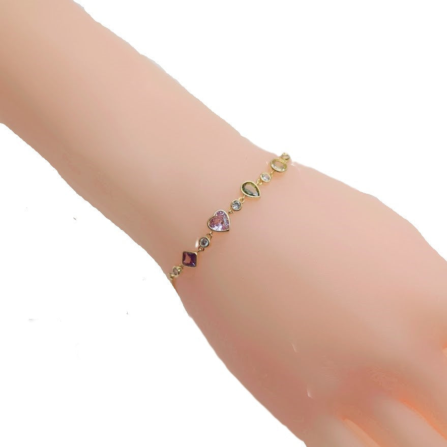 Colorful cubic zirconia tennis bracelet with diamond, heart, oval, and circle shapes, gold plated adjustable sliding design.