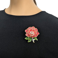 Cubic Zirconia Brooch featuring a pink and red enamel flower, clear sparkling centre stones and green leaves with gold detailing.