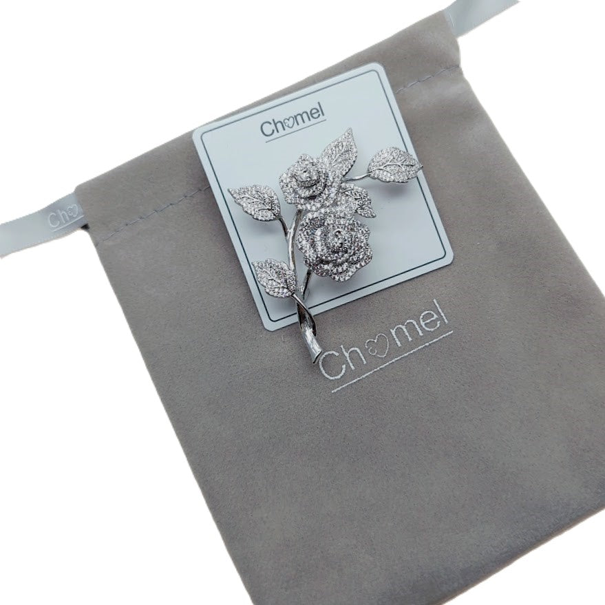 Cubic Zirconia Brooch featuring silver-tone rose flowers and leaves, densely set with sparkling stones and a dangling stem.