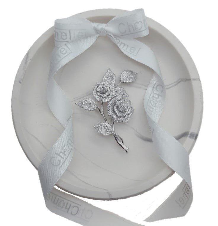 Cubic Zirconia Brooch with two silver-tone rose flowers and sparkling pavé leaves on a slender twisted stem.