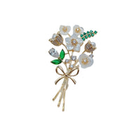 Cubic Zirconia Brooch with white enamel flowers, sparkling clear stones, green leaf accents and a gold-tone bow stem.