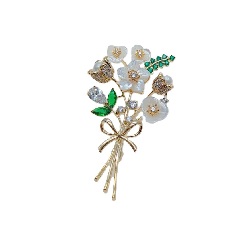 Cubic Zirconia Brooch with white enamel flowers, sparkling clear stones, green leaf accents and a gold-tone bow stem.