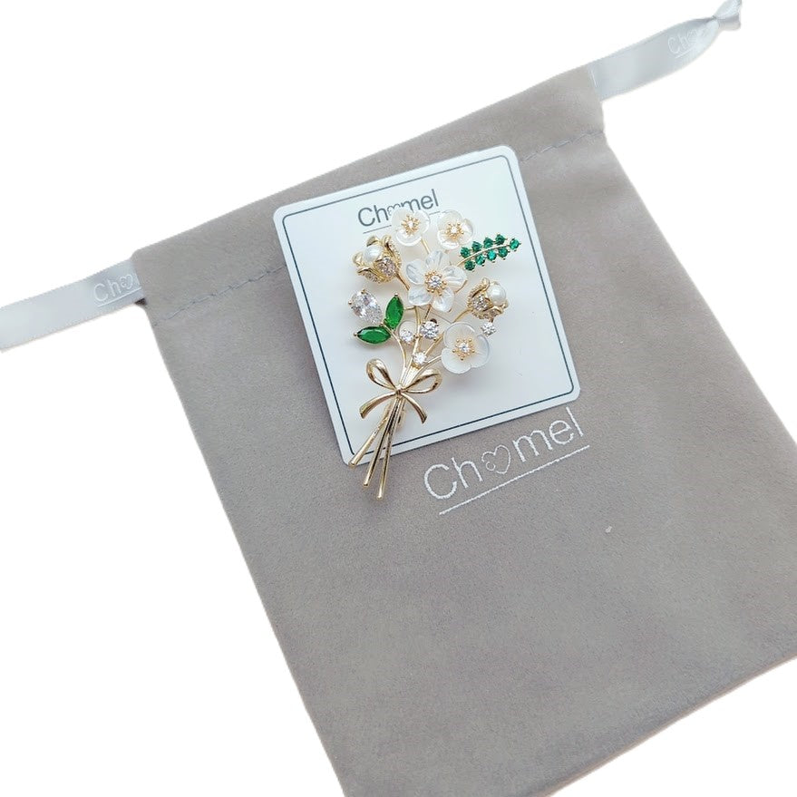 Cubic Zirconia Brooch with white flower-shaped stones, green accents and a gold-tone stem in a floral design.