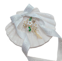 Cubic Zirconia Brooch with white enamel flower petals, green accents and a gold-tone stem embellished with clear stones.