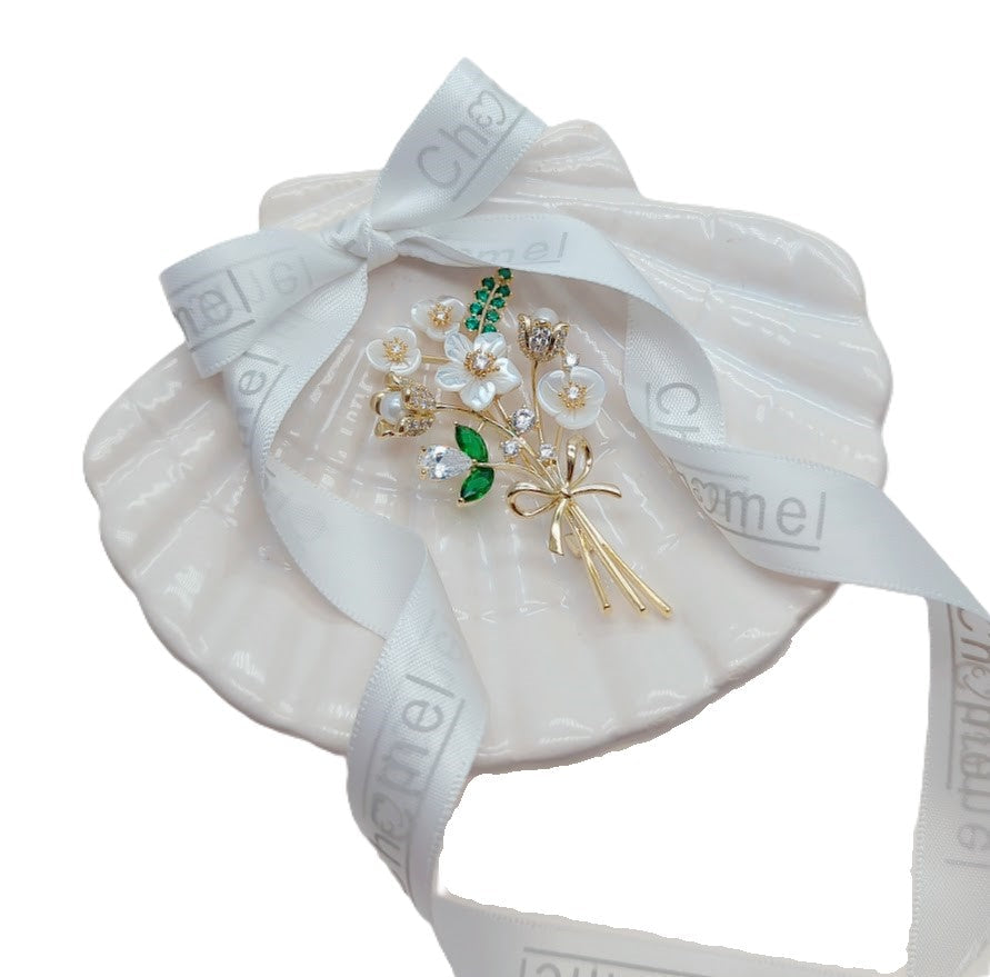 Cubic Zirconia Brooch with white enamel flower petals, green accents and a gold-tone stem embellished with clear stones.