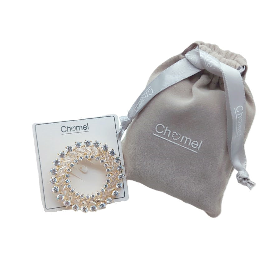 Gold plated round cubic zirconia brooch with baguette cut stones and C clasp closure, 4.5cm diameter