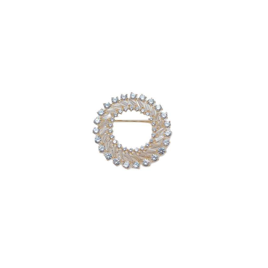 Gold plated round cubic zirconia brooch with baguette cut stones and C clasp closure