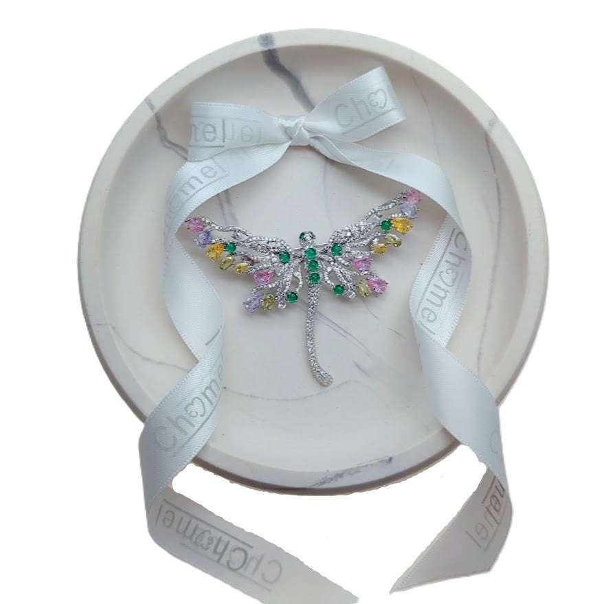 Dragonfly cubic zirconia brooch in silver-tone metal, with sparkling clear stones and colourful pastel accents on its wings.