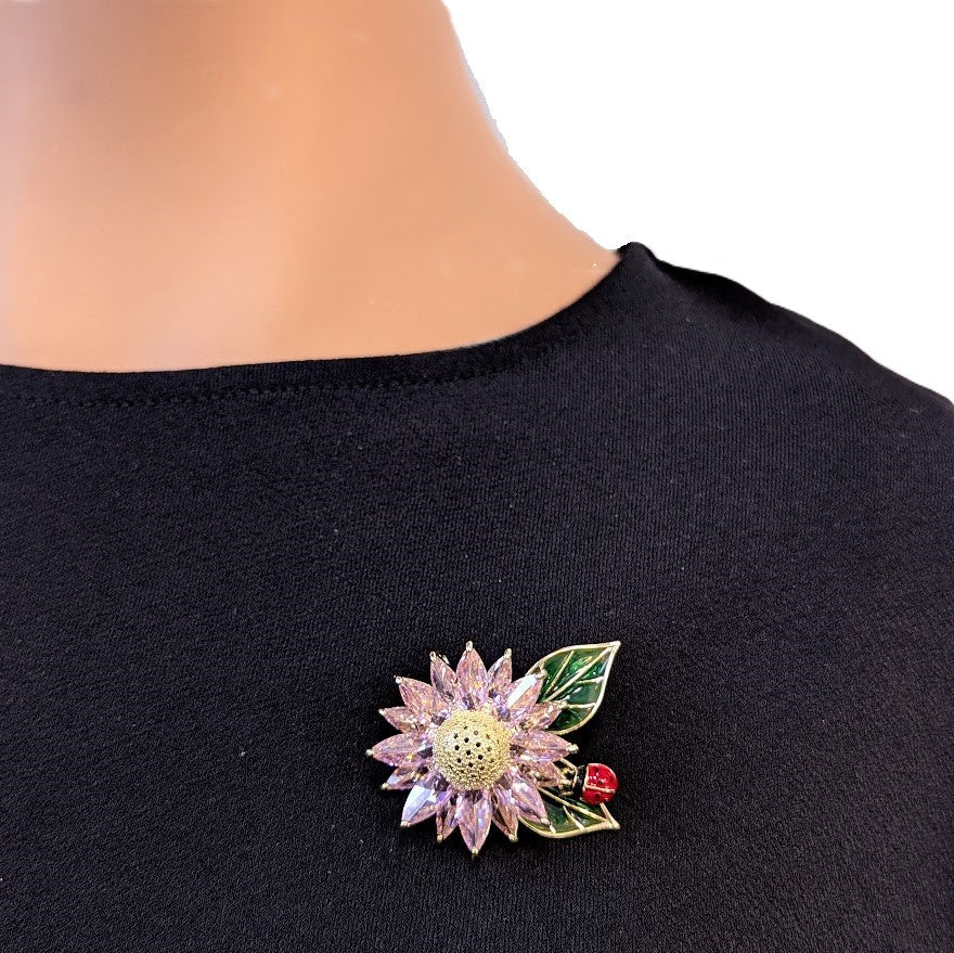 Pink cubic zirconia flower cubic zirconia brooch with green enamel leaves and red beetle detail, gold plated, 4.1cm x 3.6cm.