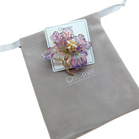 Cubic Zirconia Brooch with a purple and pink iridescent flower, gold-tone detailing and pearl-like centre.