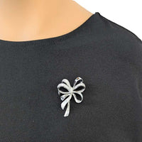 Rhodium plated ribbon cubic zirconia brooch with fluid design and clasp closure