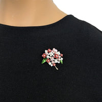 Cubic Zirconia Brooch featuring a gold-tone flower bouquet with red, pink and white enamel petals, green leaves and sparkling stones.