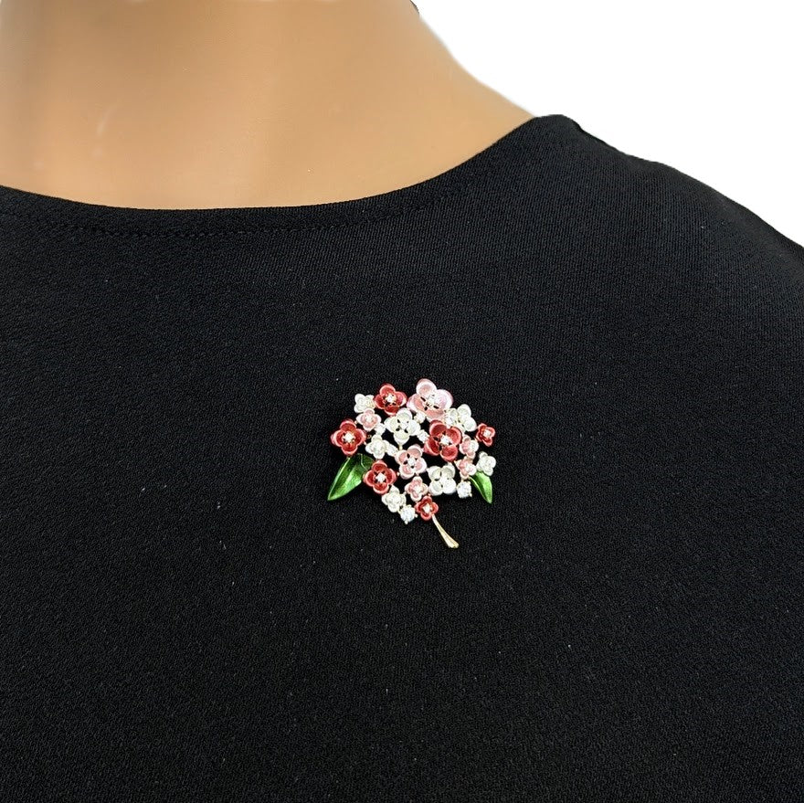 Cubic Zirconia Brooch featuring a gold-tone flower bouquet with red, pink and white enamel petals, green leaves and sparkling stones.