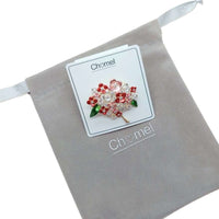 Floral Cubic Zirconia Brooch with red and pink flowers, clear sparkling stones, green leaves and gold-tone stems.
