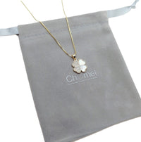 Gold-tone clover pendant necklace with a delicate chain and pearl-like inlay beside sparkling Butterfly Cubic Zirconia stones.