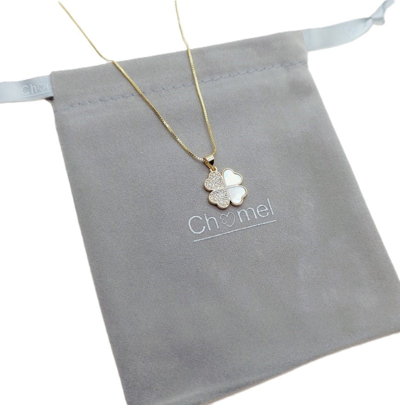 Gold-tone clover pendant necklace with a delicate chain and pearl-like inlay beside sparkling Butterfly Cubic Zirconia stones.