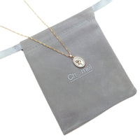 Gold-tone fine chain necklace with oval mother-of-pearl pendant, gold flower detail and sparkling border; Butterfly Cubic Zirconia style.