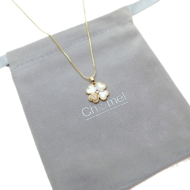 Clover pendant necklace in gold-tone metal with white mother-of-pearl petals and a sparkling accent; Butterfly Cubic Zirconia detail.