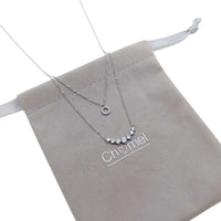 Tiered cubic zirconia necklace with round pendant and graduating solitaire on rhodium plated chain