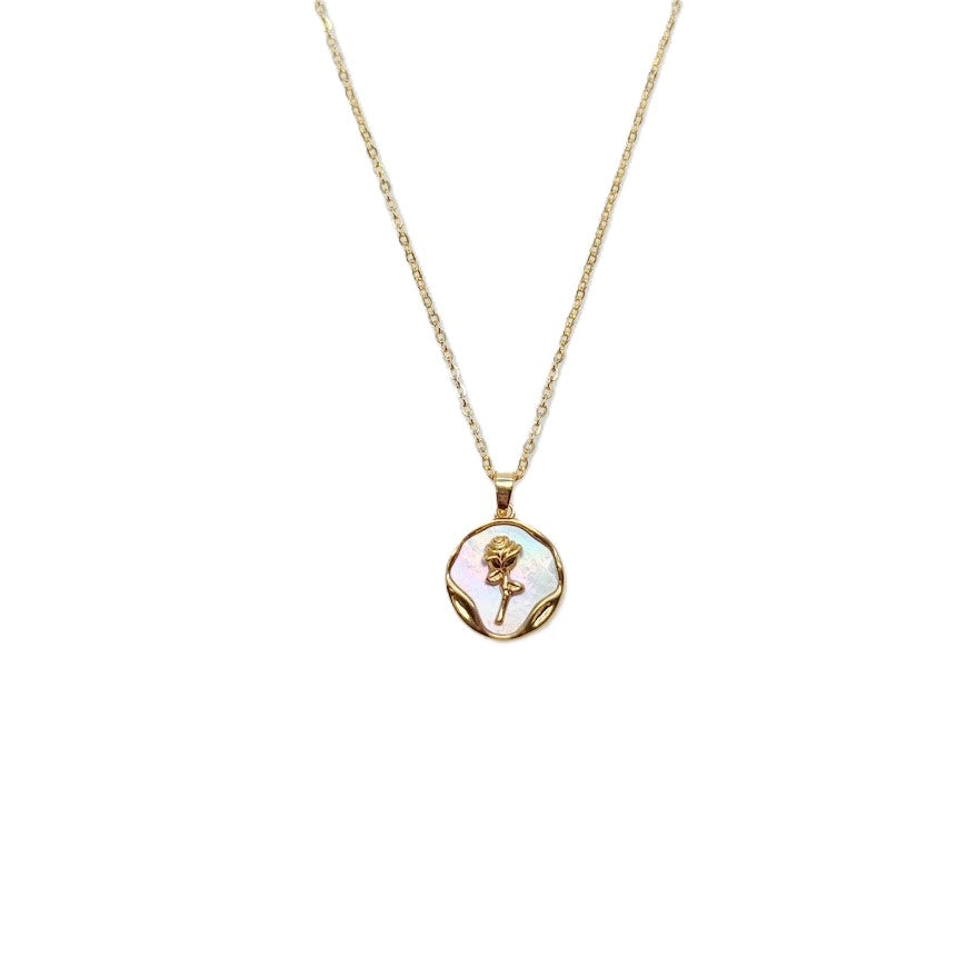 Gold-toned necklace with a round mother-of-pearl pendant, wavy border and flower detail; Butterfly Cubic Zirconia style.