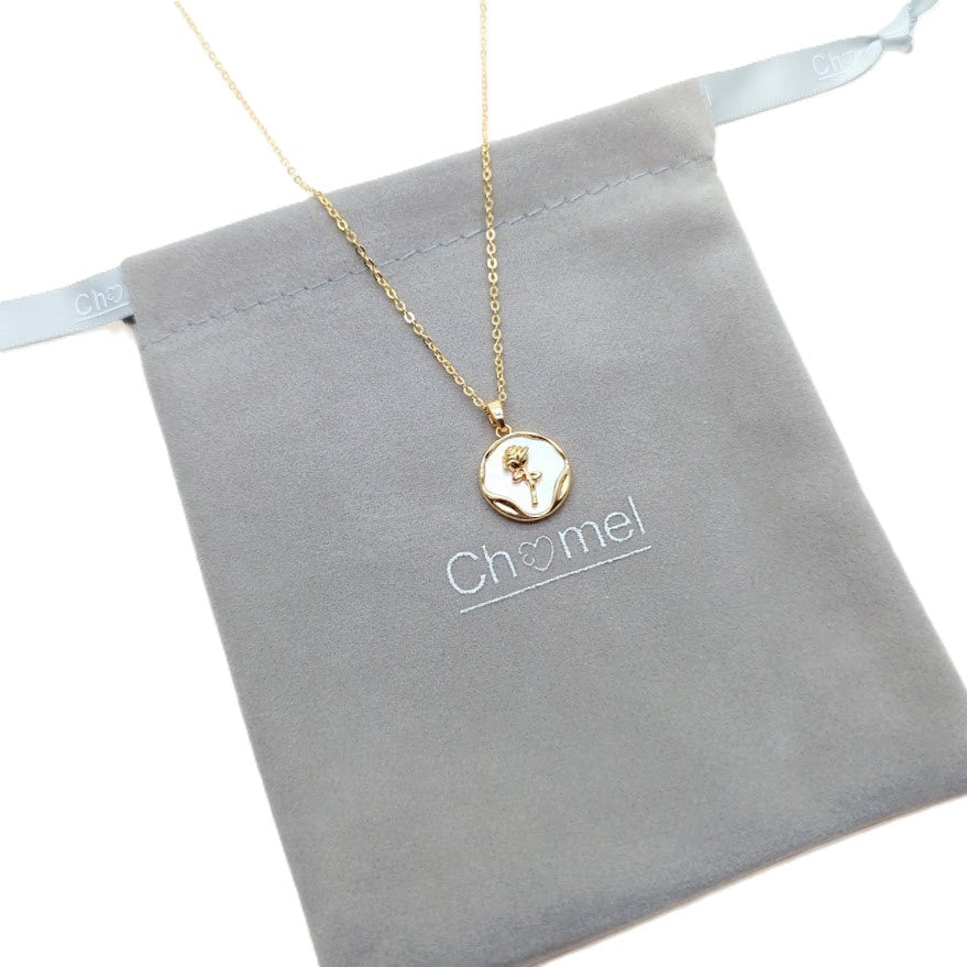 Gold-tone chain necklace with round mother-of-pearl pendant, wavy gold border and flower detail; Butterfly Cubic Zirconia necklace.