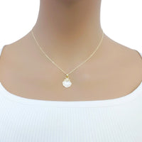 Seashell pendant necklace with a delicate gold-tone chain and iridescent white shell charm; Butterfly Cubic Zirconia detail.