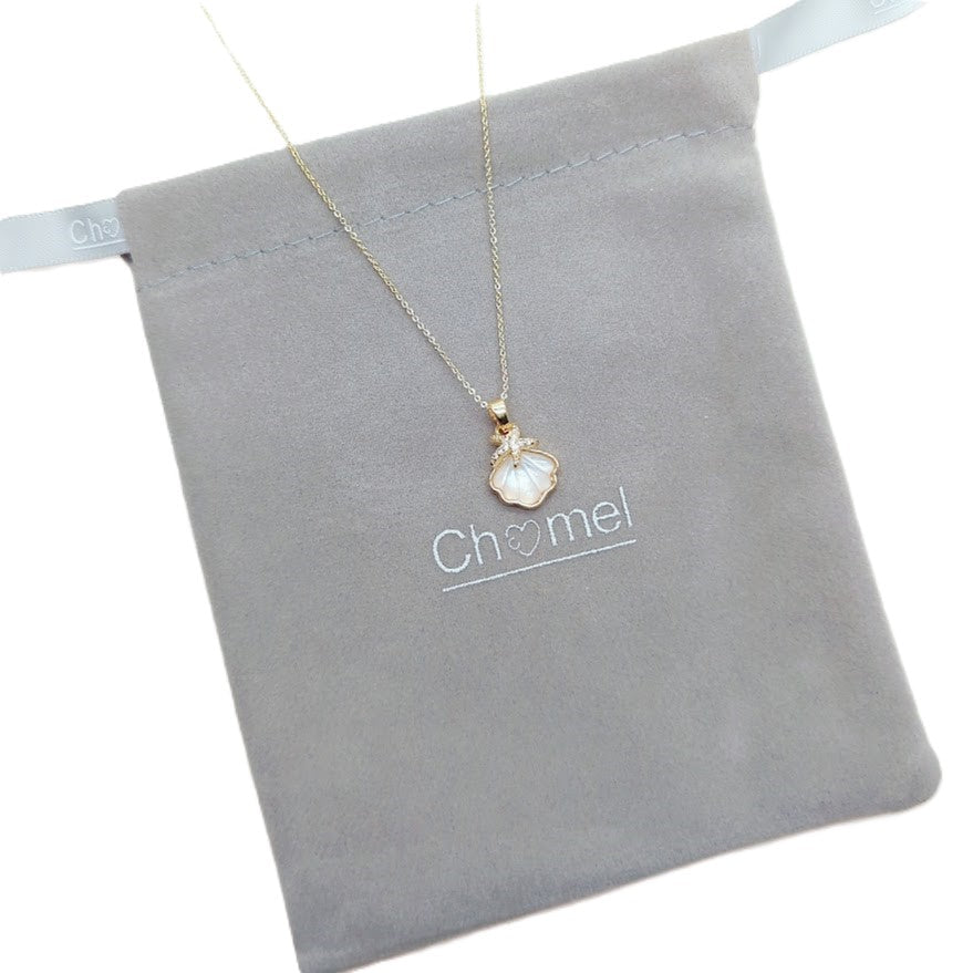 Gold-tone necklace with a delicate chain and white shell-shaped pendant, featuring a textured pearl-like surface; Butterfly Cubic Zirconia style.