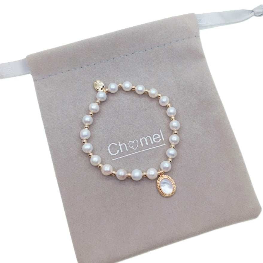 Freshwater pearl bracelet with gold beads and oval simulated moonstone charm on elastic band