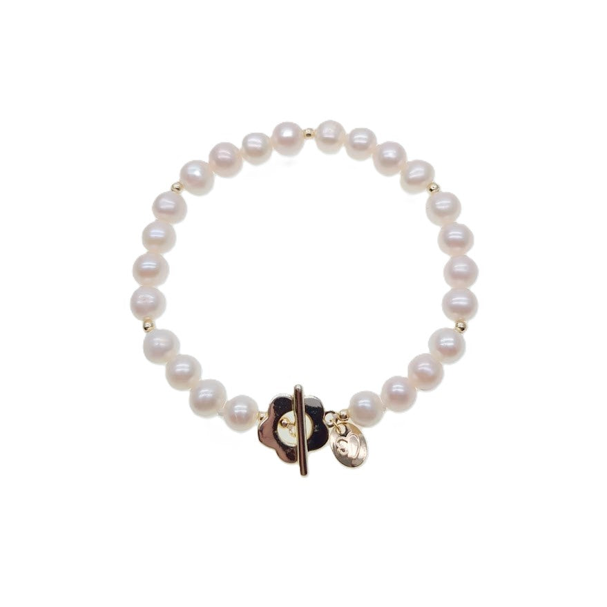 Freshwater pearl bracelet with alternating gold beads and flower-shaped toggle clasp on elastic band