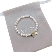 Freshwater pearl bracelet with alternating gold beads and flower-shaped gold toggle clasp on elastic band