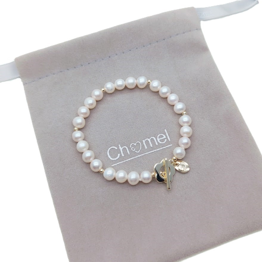 Freshwater pearl bracelet with alternating gold beads and flower-shaped gold toggle clasp on elastic band