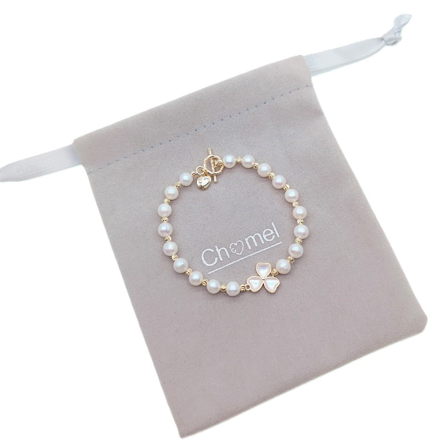 Freshwater pearl bracelet with gold beads and simulated moonstone three-leaf clover centerpiece on gold toggle clasp
