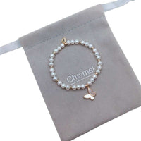 Freshwater pearl bracelet with gold beads and butterfly charm on elastic band