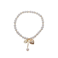 Freshwater pearl bracelet with alternating gold beads and heart charm on elastic band