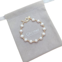 Freshwater Pearl Bracelet featuring white 9mm pearls alternating with small gold beads and a gold-plated toggle clasp