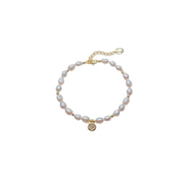 Freshwater Pearl Bracelet with 4-5mm rice-shaped pearls, gold beads, and a gold plated round charm with spring clasp.