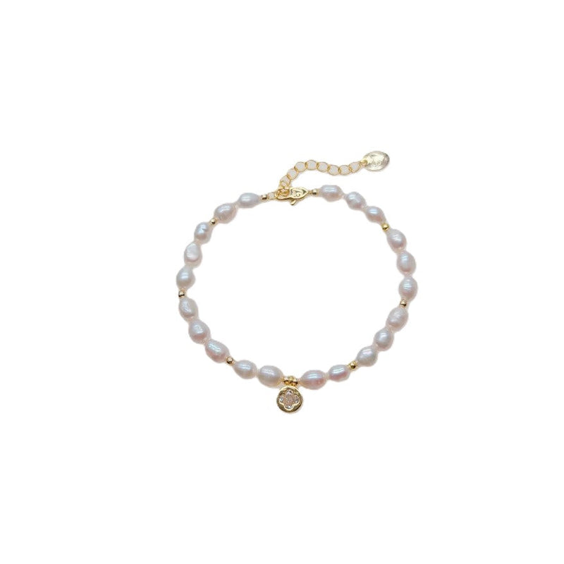 Freshwater Pearl Bracelet with 4-5mm rice-shaped pearls, gold beads, and a gold plated round charm with spring clasp.