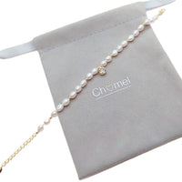 Freshwater Pearl Bracelet with white rice-shaped pearls, gold beads, and a gold-plated round charm on a delicate chain