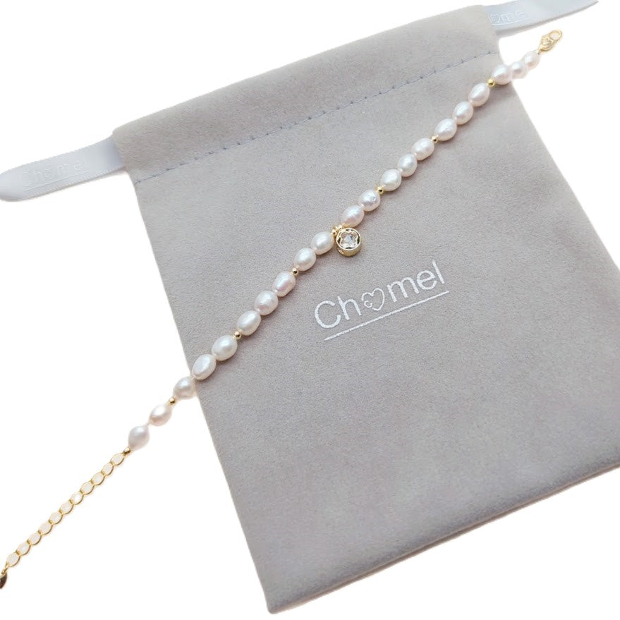 Freshwater Pearl Bracelet with white rice-shaped pearls, gold beads, and a gold-plated round charm on a delicate chain
