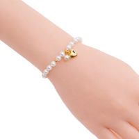 Freshwater Pearl Bracelet featuring white freshwater pearls alternating with small gold beads and a gold plated heart charm with pearl detail.
